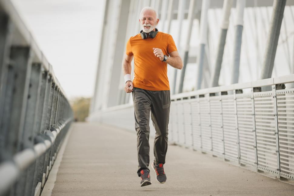 Free Image of Senior man jogging on a bridge 