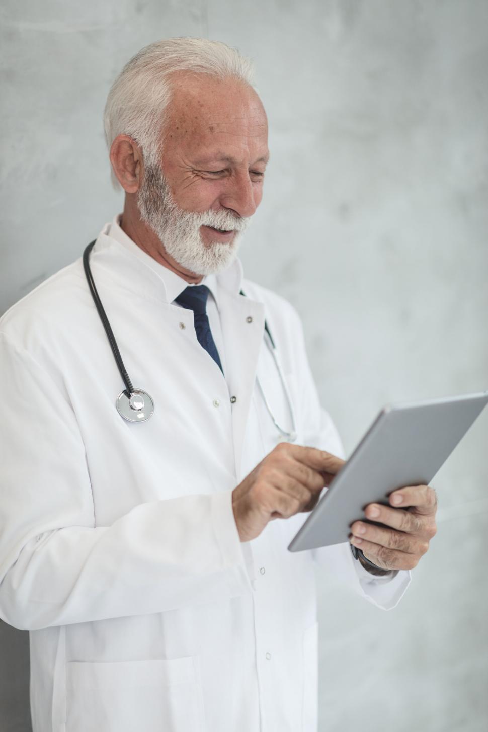 Free Image of Doctor examining medical data on tablet 