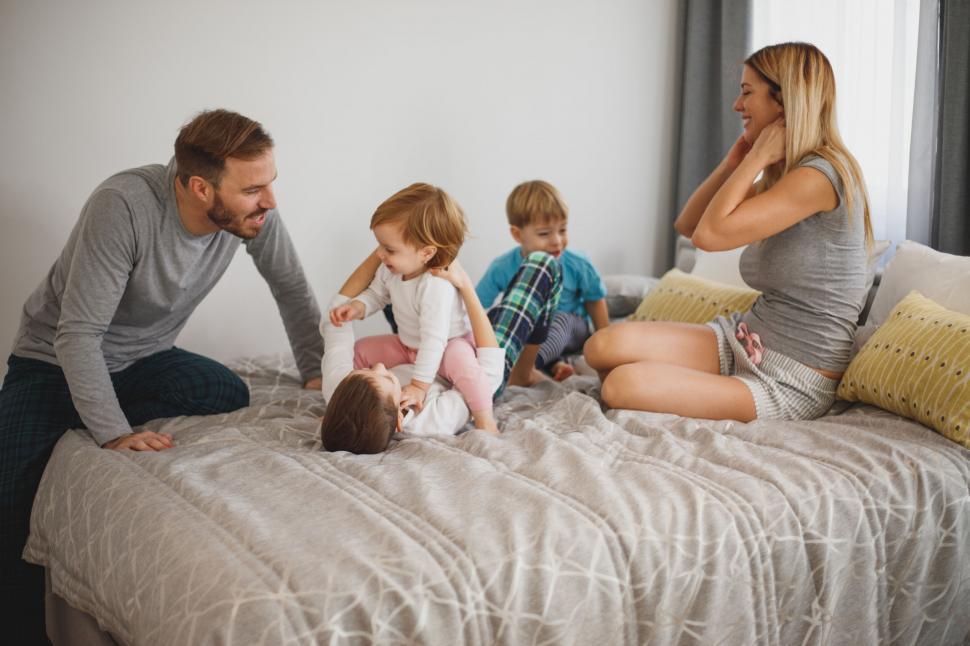 Free Image of Family fun on cozy bedroom bed 