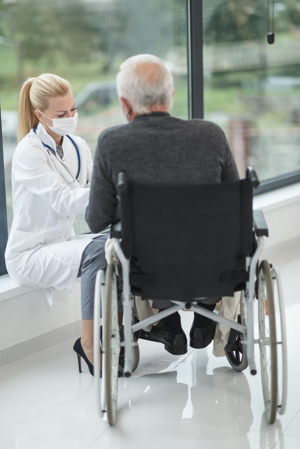 Free Image of Doctor consulting with elderly patient in wheelchair 