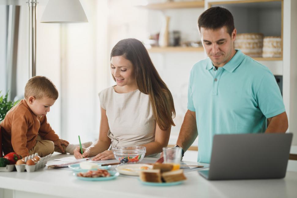 Free Image of Family in kitchen with child cooking and laptop 
