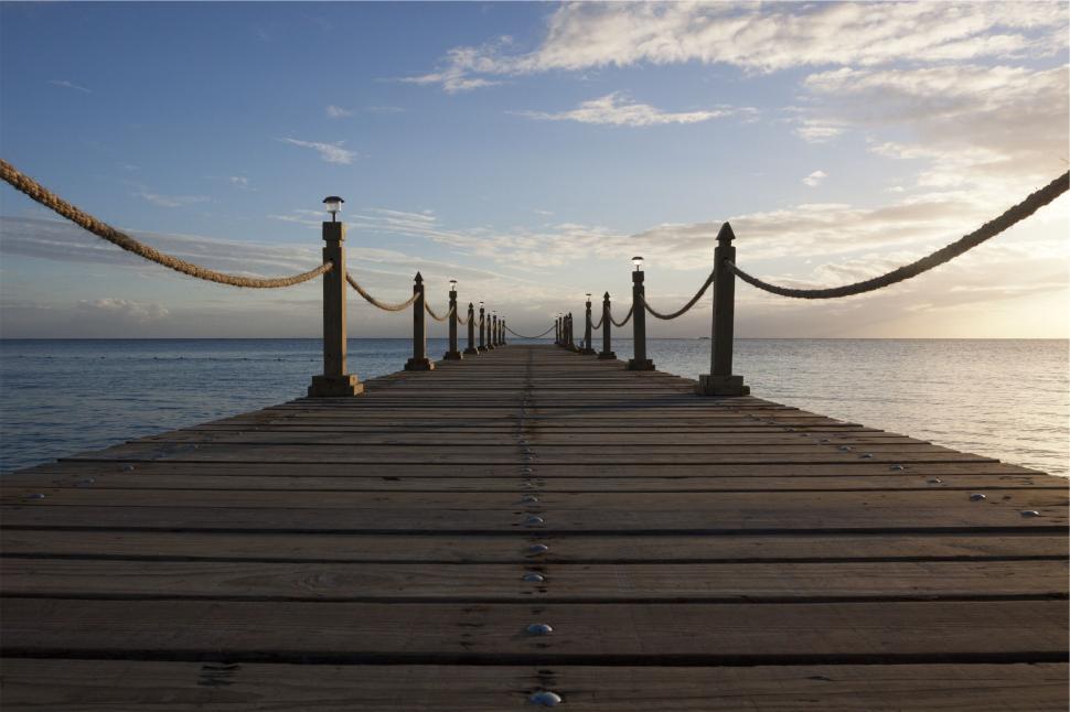 Free Image of Sunrise at the wooden pier over calm sea 