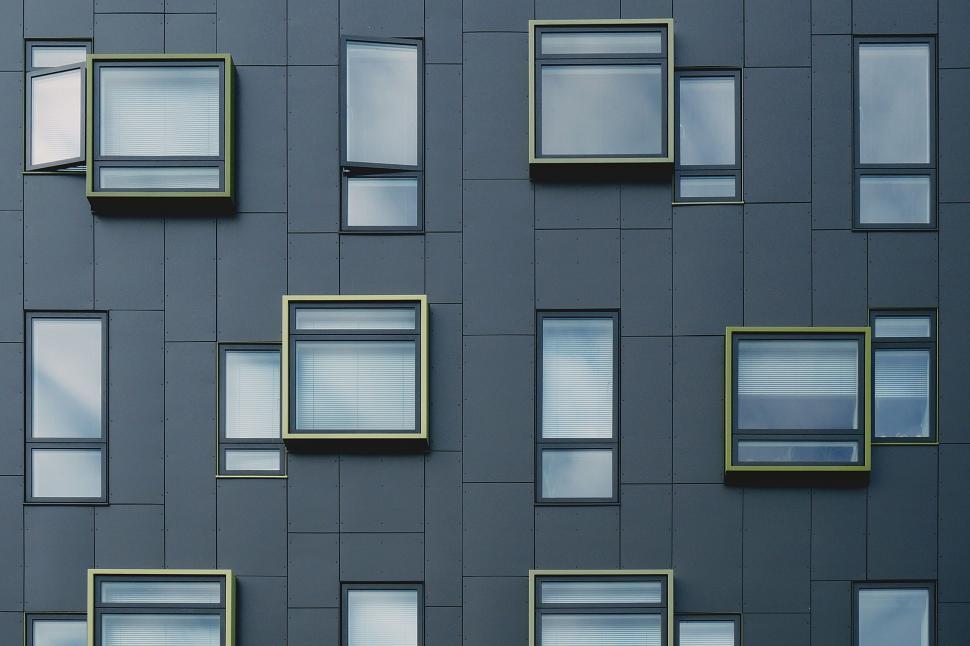 Free Image of Pattern of colorful windows on dark facade 