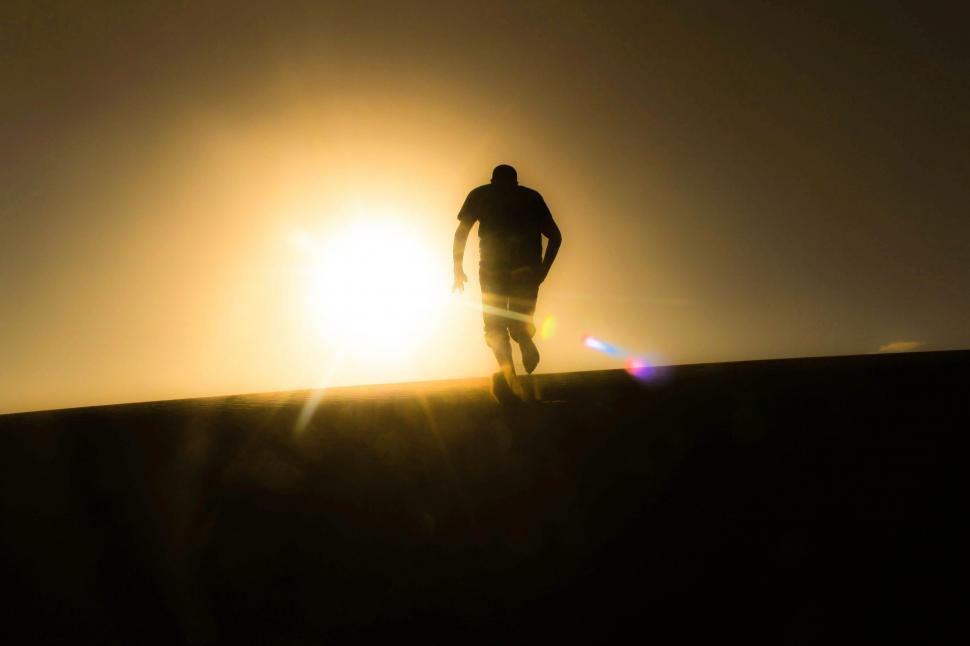 Free Image of Silhouette of a man running towards the sunset 