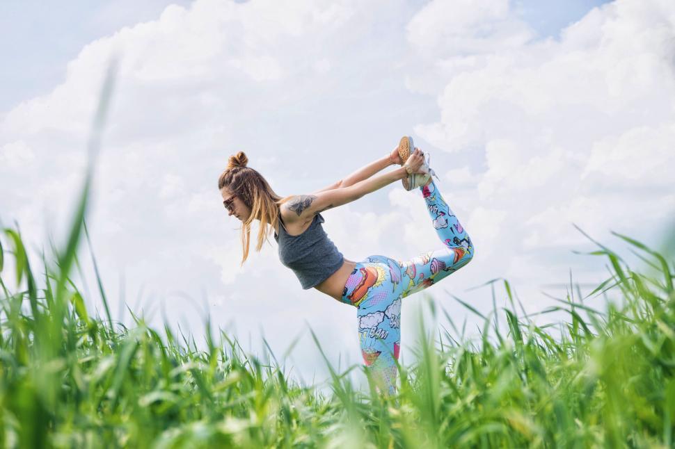 Free Image of Woman practicing yoga in a field 