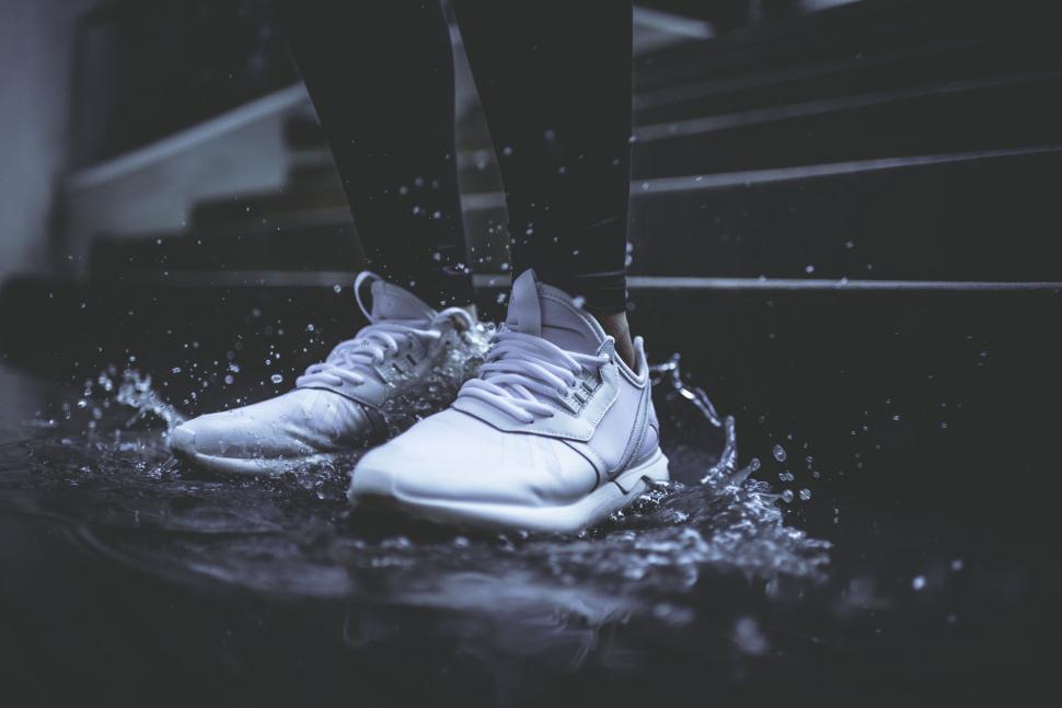 Free Image of White sneakers splashing water on stairs 