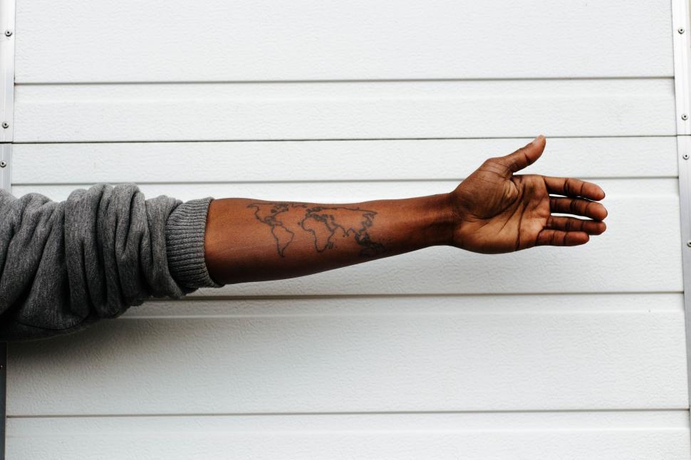 Free Image of Arm extended against white wall 