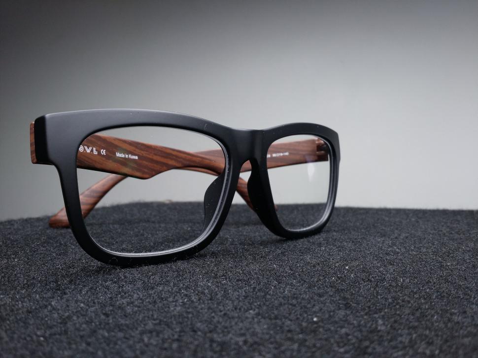 Free Image of Black eyeglasses with wooden temples on fabric 