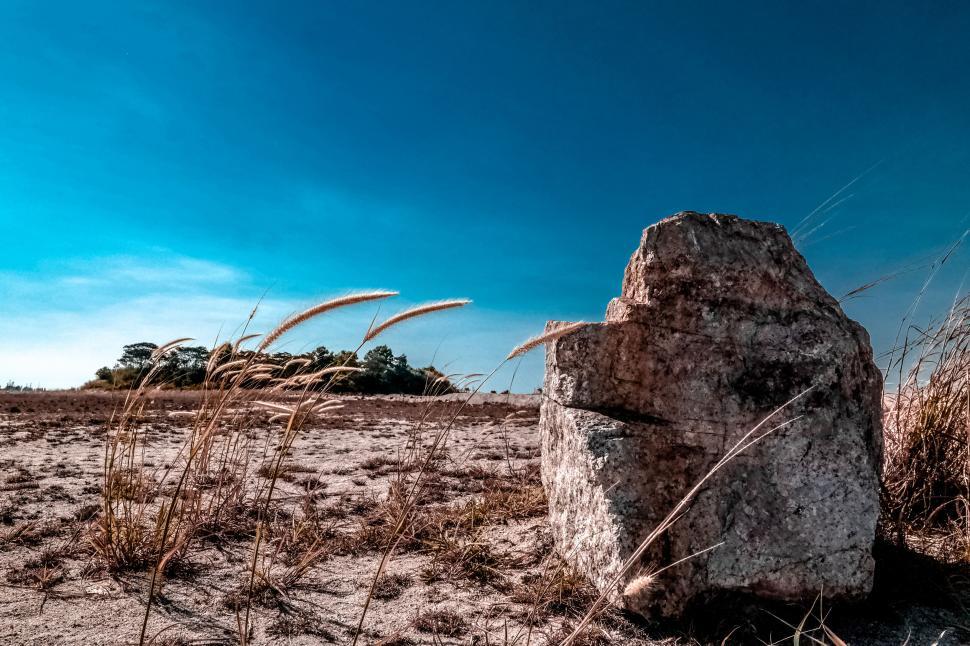 Free Image of Stone on Dry Grass Field with Clear Blue Sky 