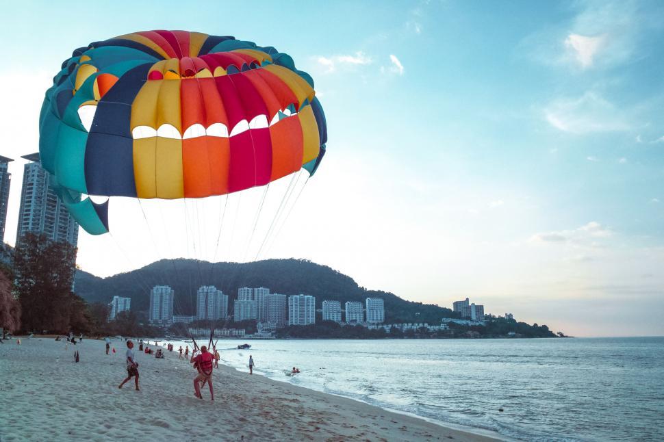 Free Image of Colorful parasailing against a sunset sky 