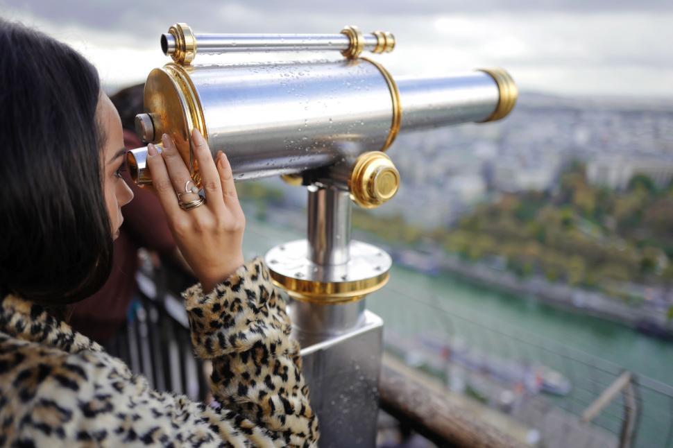 Free Image of Woman using telescope on city skyline 