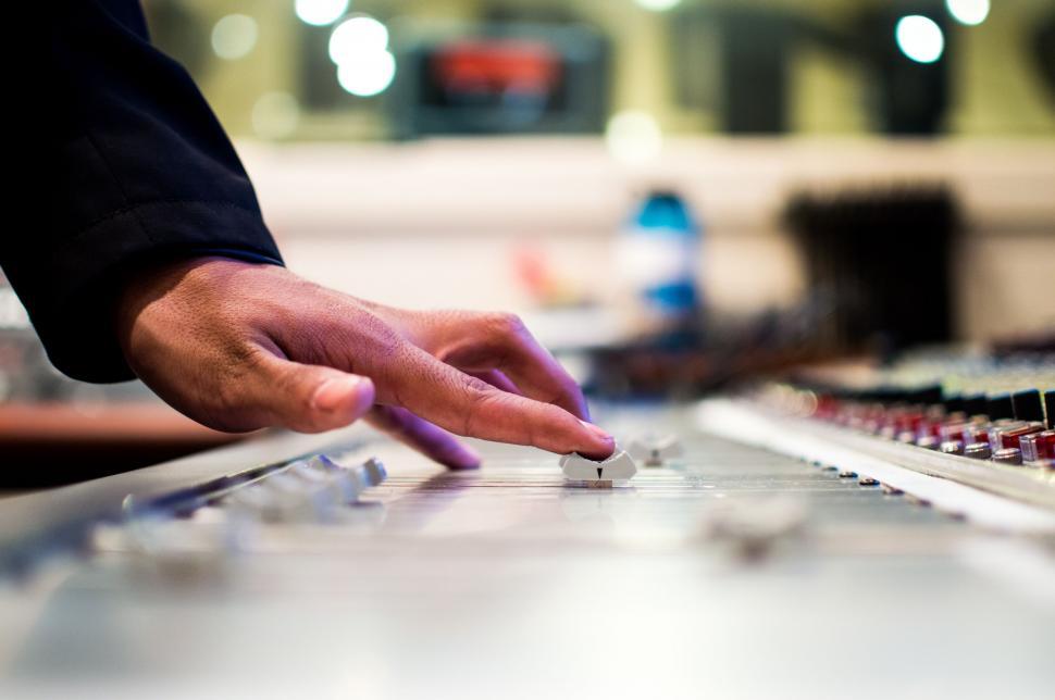 Free Image of Close-up of sound engineer s hand on mixer 