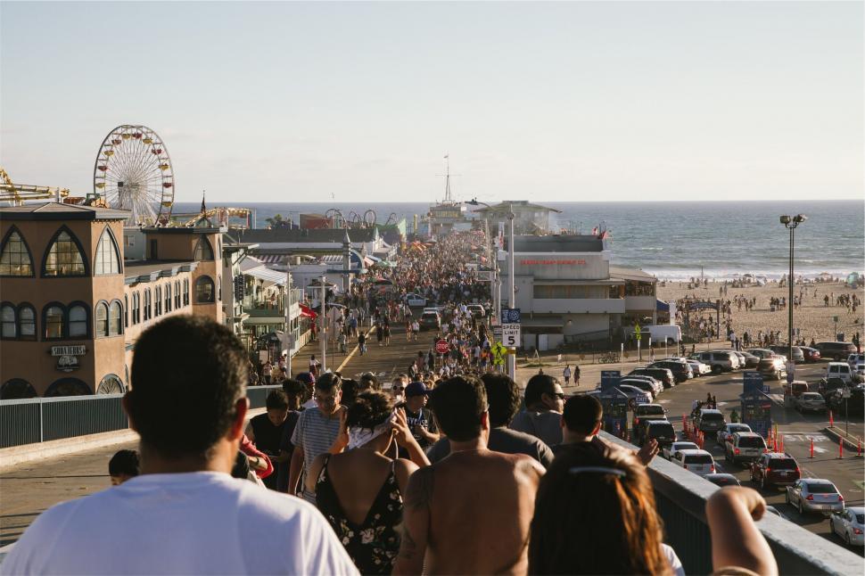 Free Image of Bustling beach boardwalk with pier in background 