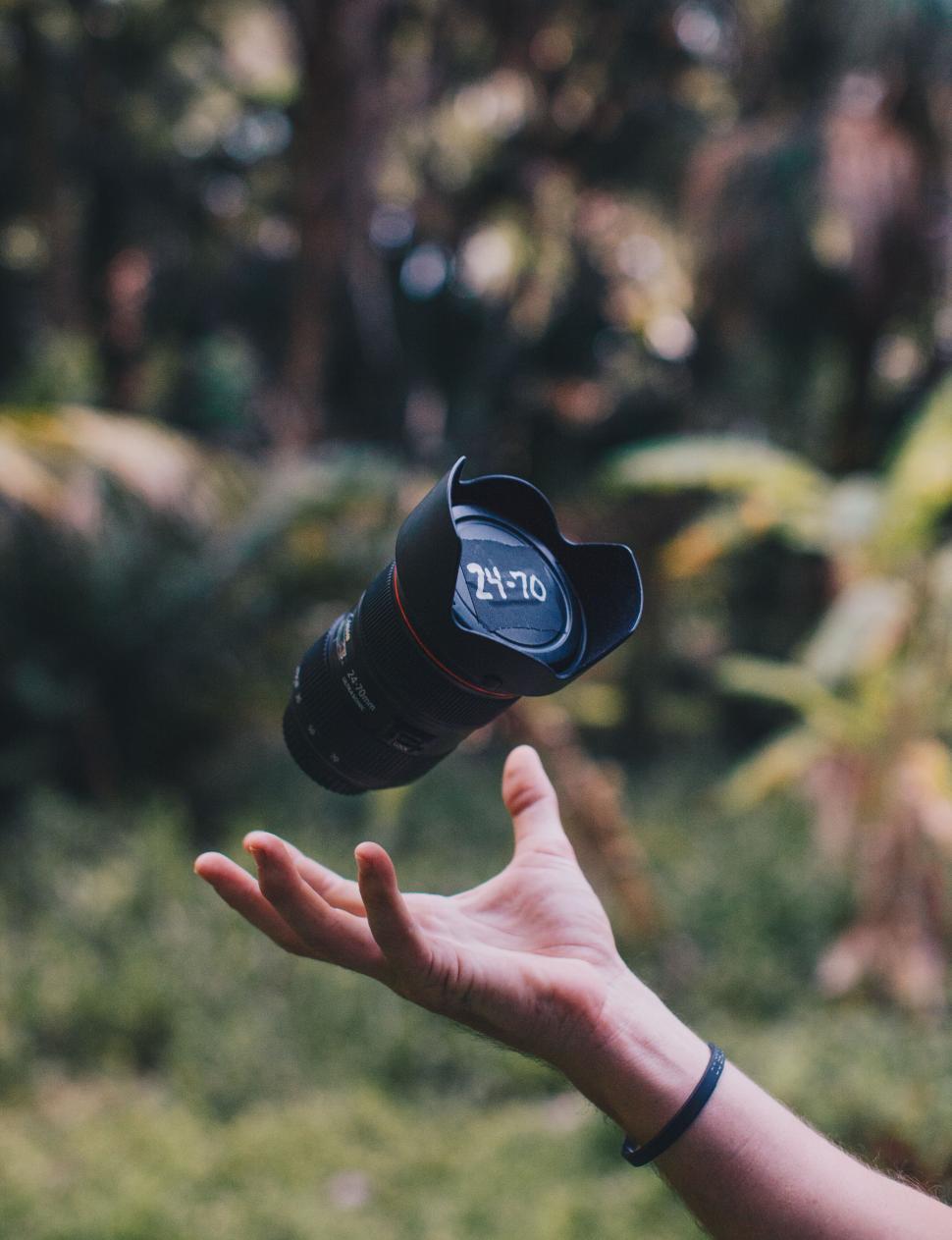 Free Image of Camera lens levitating above a hand 