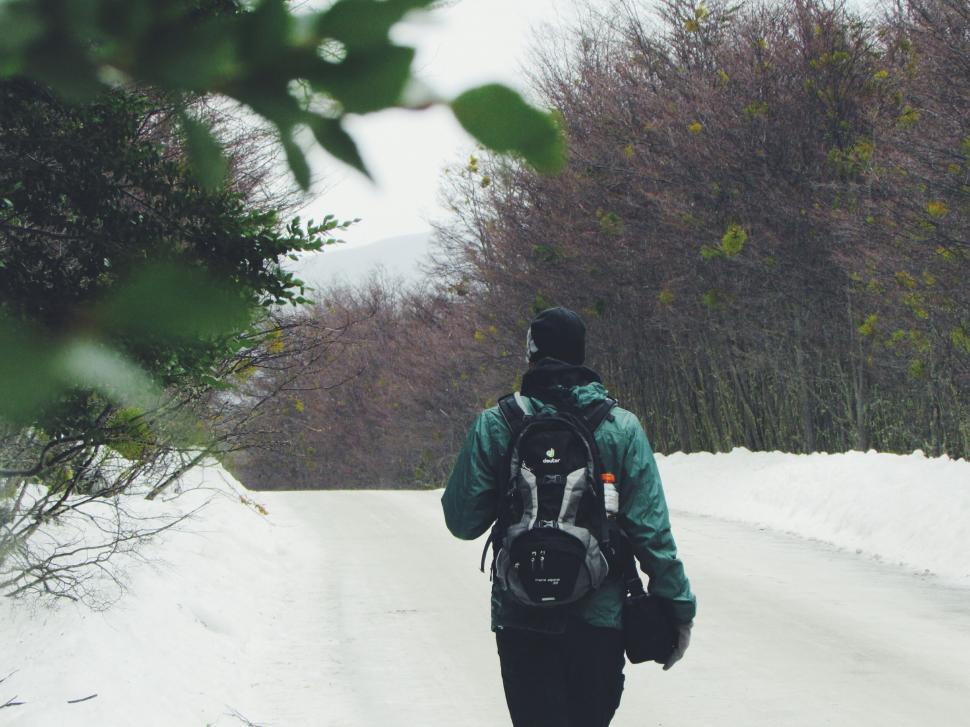 Free Image of Lone traveler trekking through snowy forest 