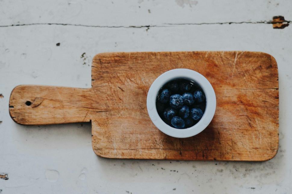 Free Image of Blueberries in a bowl on rustic cutting board 