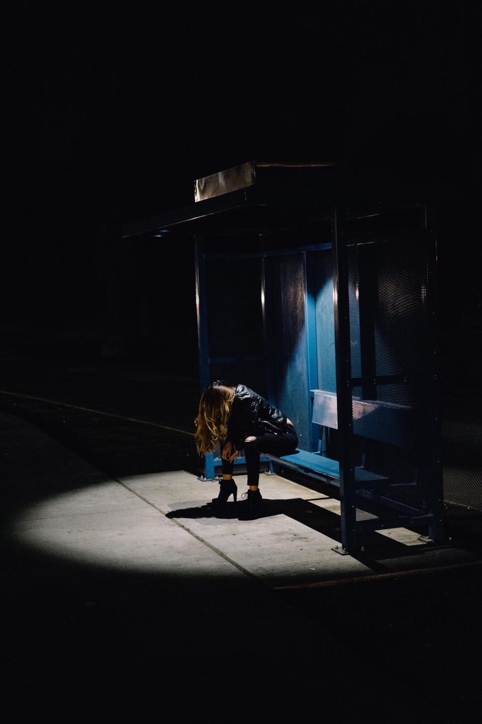 Free Image of Lonely figure at night at a bus stop 