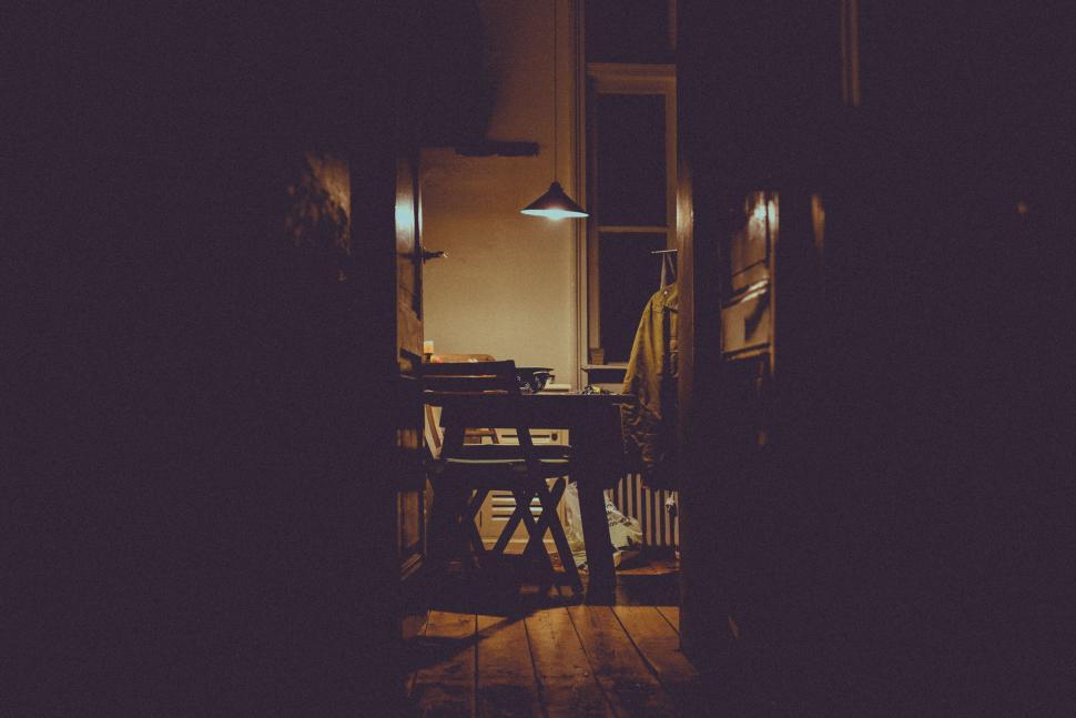 Free Image of Dimly lit room with desk and chair 