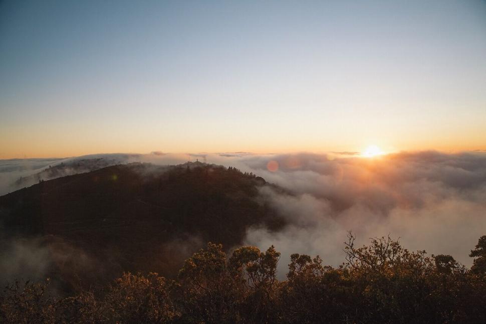 Free Image of Sunrise peeking through foggy hills 