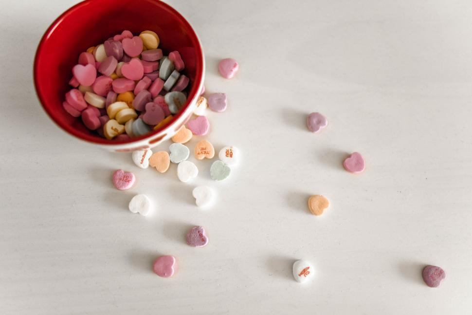 Free Image of Overhead view of colorful candy hearts spilled 