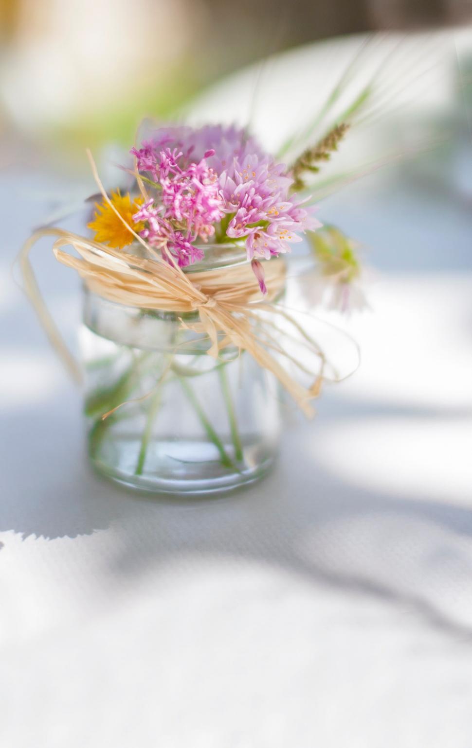 Free Image of Elegant wildflowers in a mason jar with ribbon 