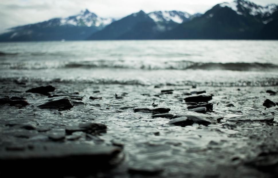Free Image of Close-up of icy lake shore with pebbles 