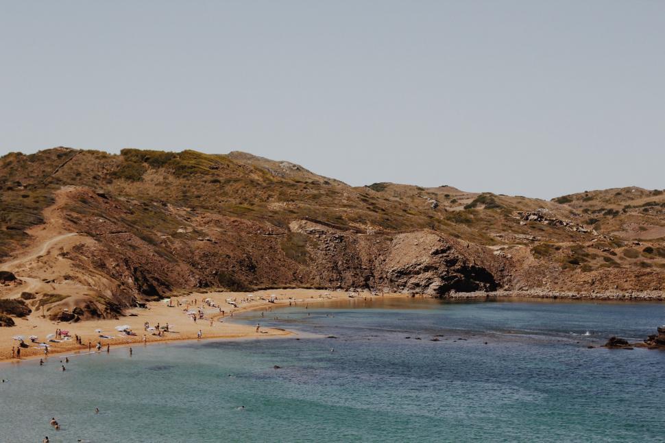 Free Image of Secluded beach with people enjoying the sun 