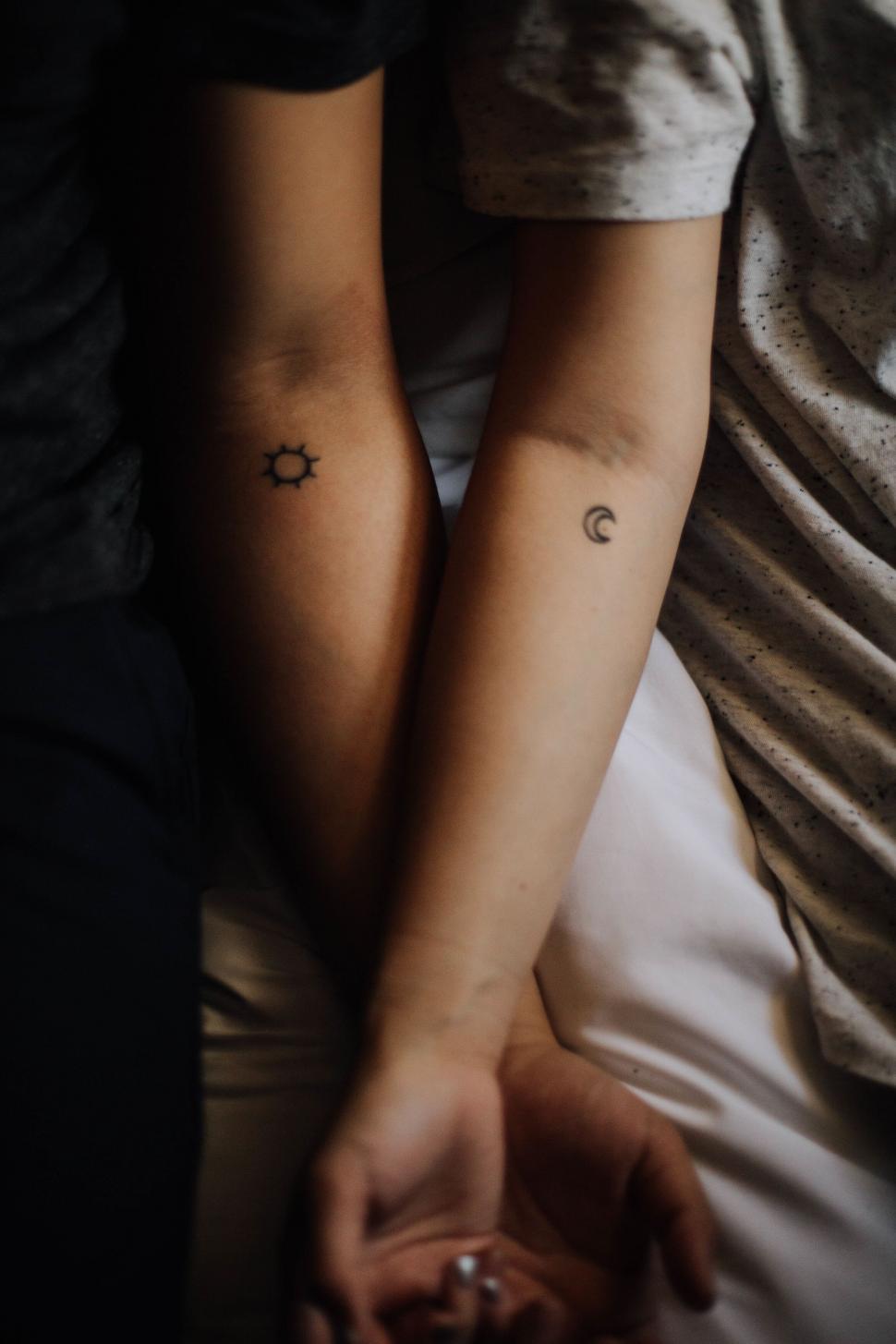 Free Image of Intimate tattooed arms holding each other 