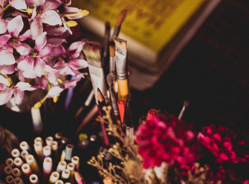 Free Image of Artistic array of paintbrushes and flowers 