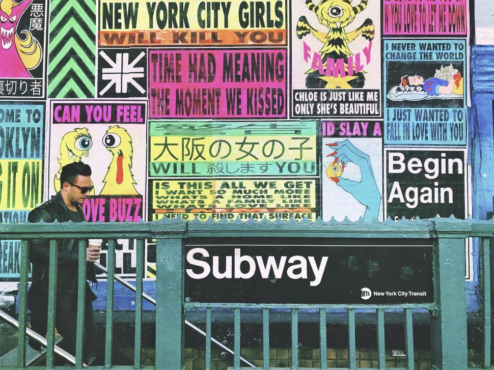 Free Image of NYC subway entrance with vibrant posters 