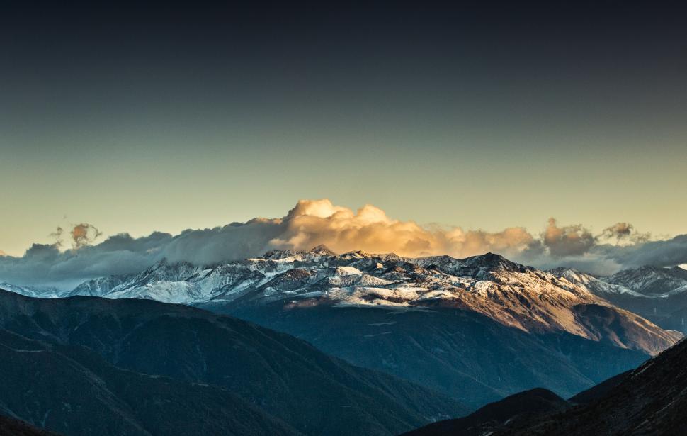 Free Image of Golden sunset over snow-capped mountains 