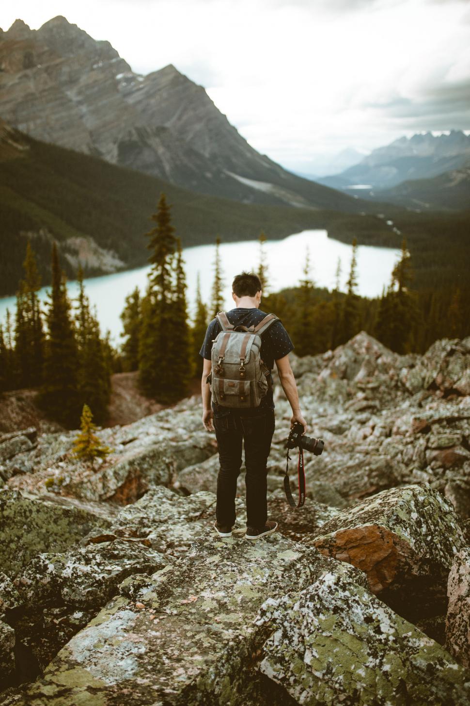Free Image of Backpacker admiring a majestic mountain lake view 