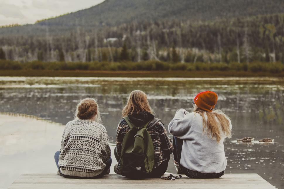 Free Image of Three friends sitting by a forest lake 