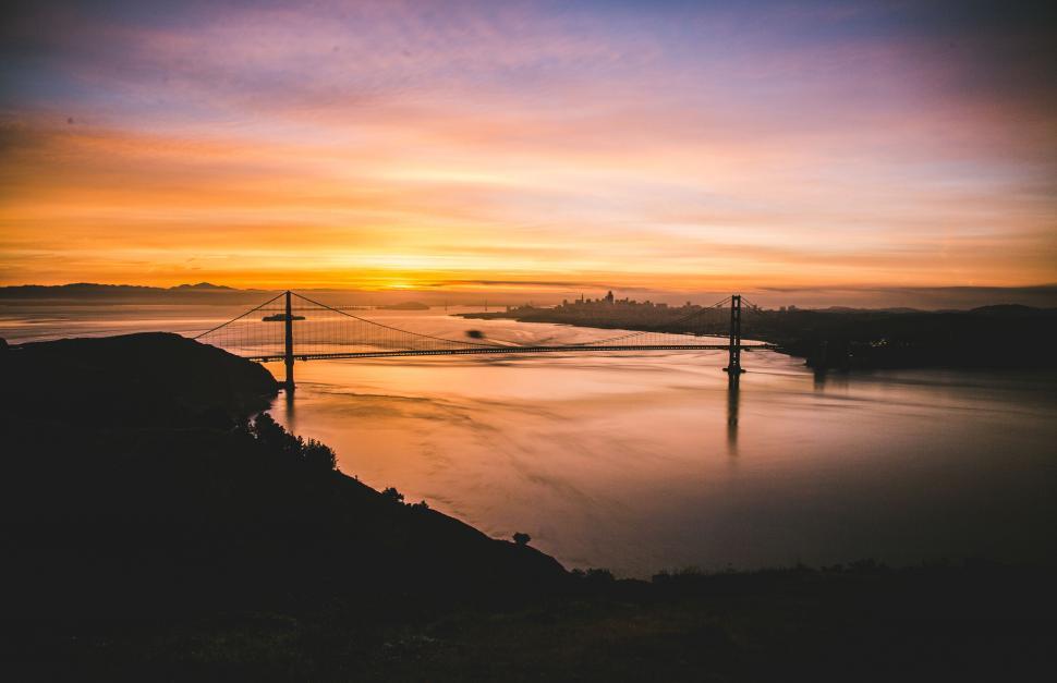 Free Image of Sunset over bridge with city in distance 