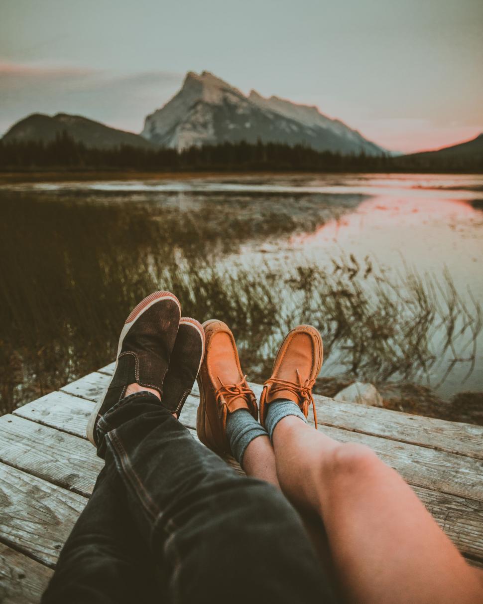 Free Image of Two people relaxing with feet up at dusk 