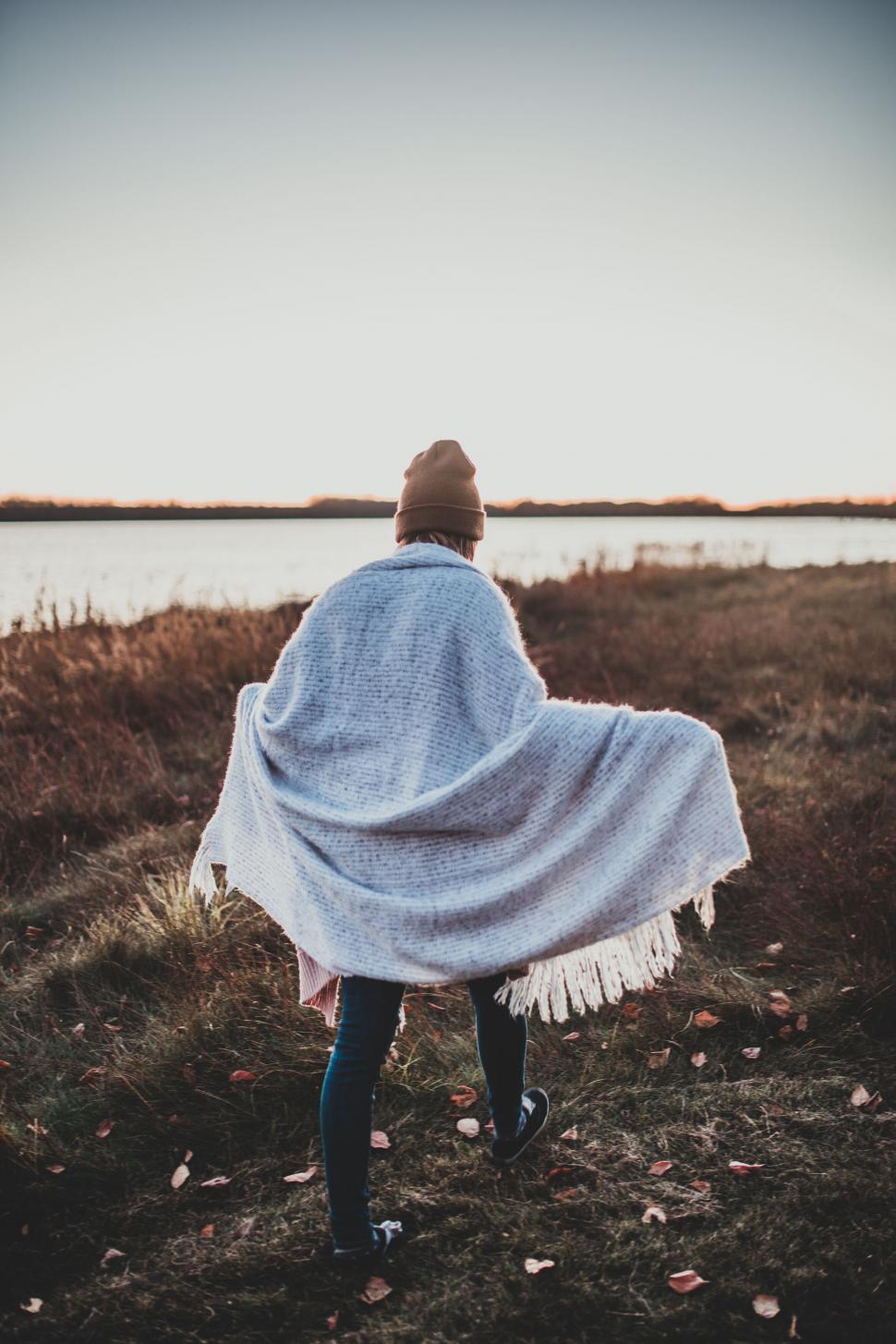 Free Image of Individual wrapped in a blanket at sunset 