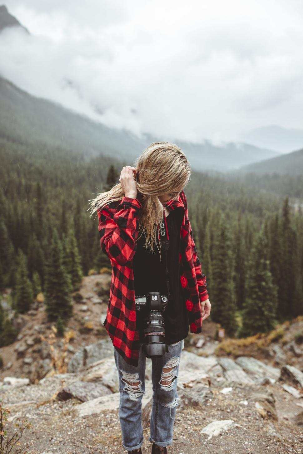 Free Image of Woman hiker with camera in mountainous woods 