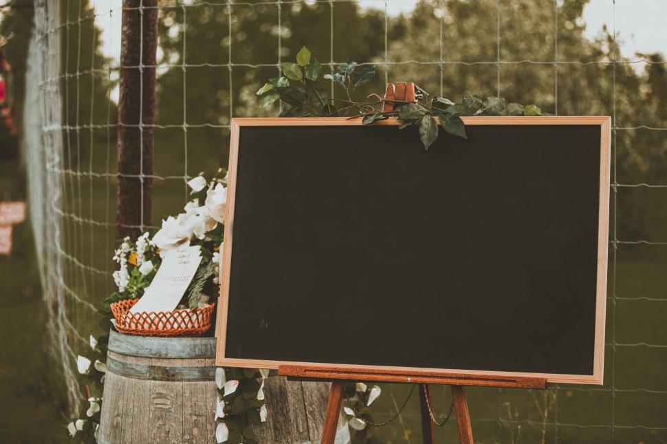 Free Image of Chalkboard on a rustic barrel with floral decor 