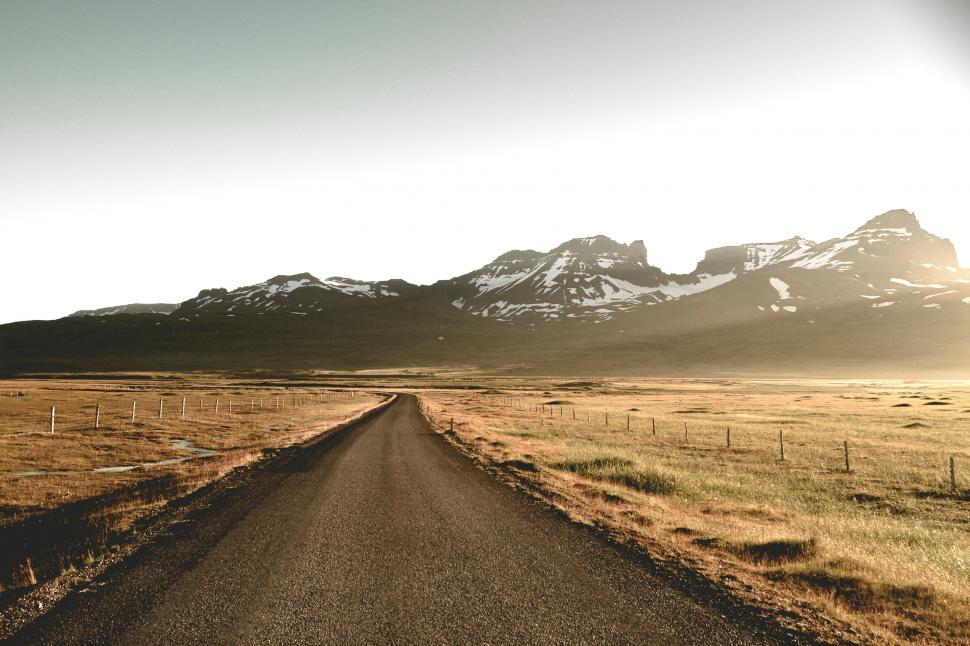 Free Image of Sunlit road heading towards snowy mountains 