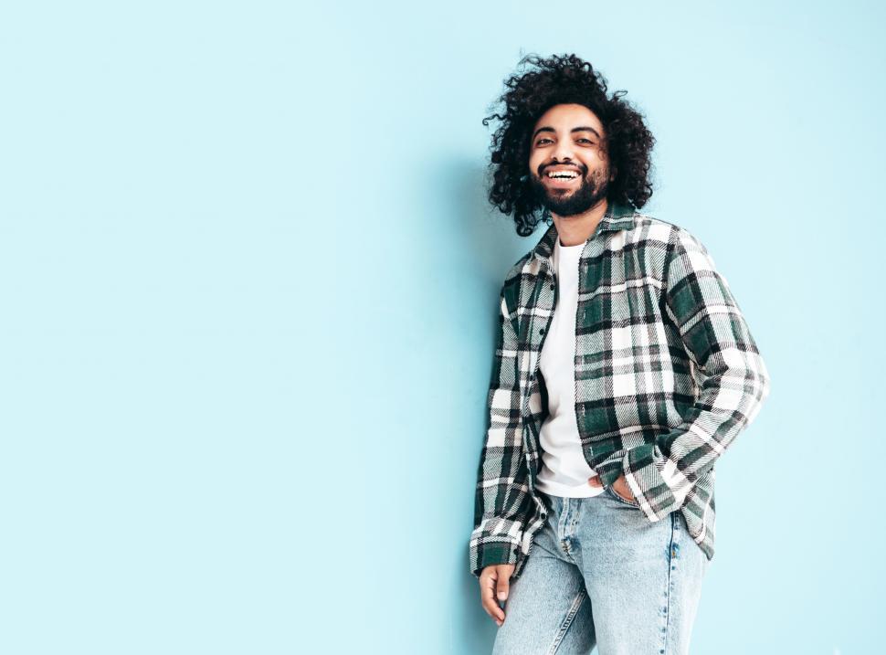 Free Image of A man with curly hair and a plaid shirt 
