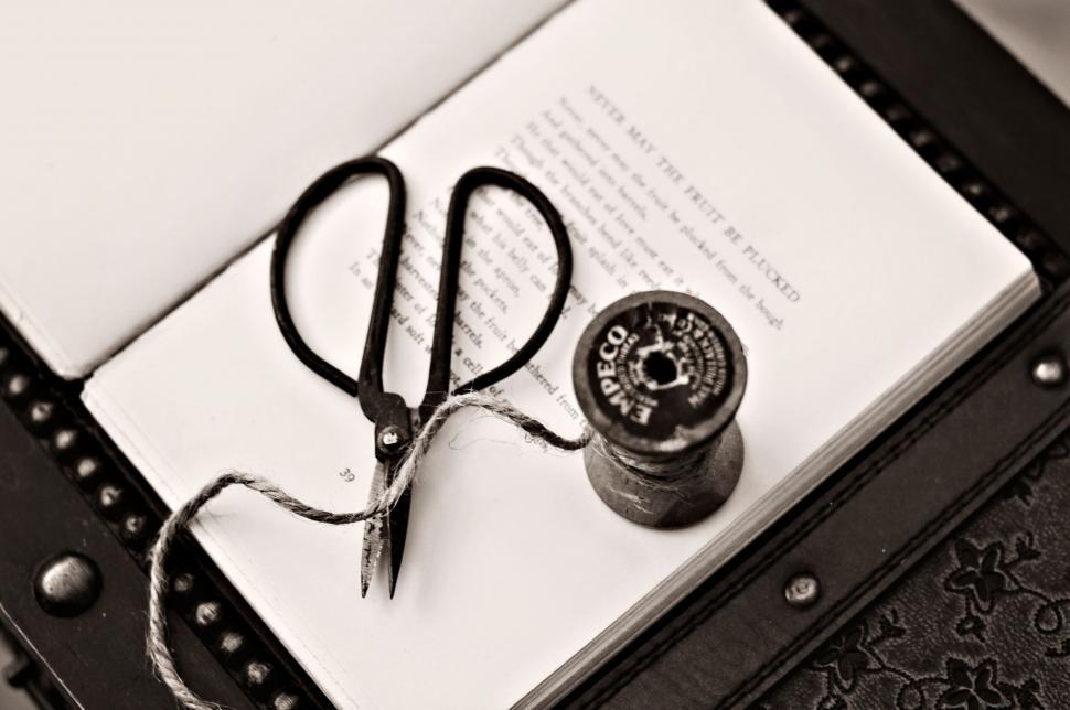 Free Image of Classic scissors and spools on a book page 