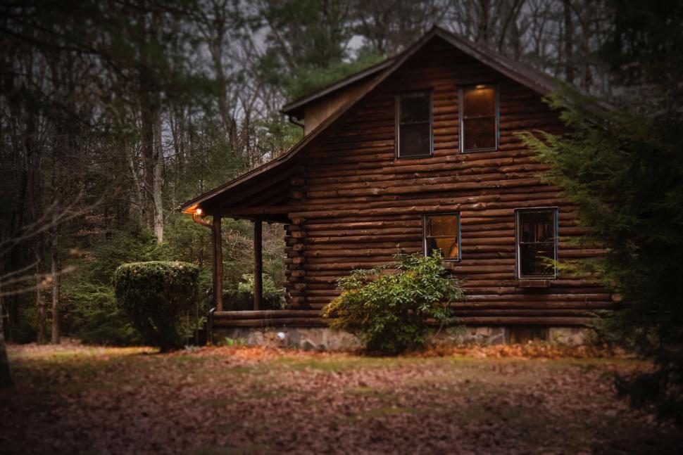 Free Image of Cozy log cabin nestled in the woods at dusk 