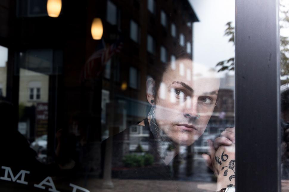 Free Image of Tattooed person behind glass reflection 