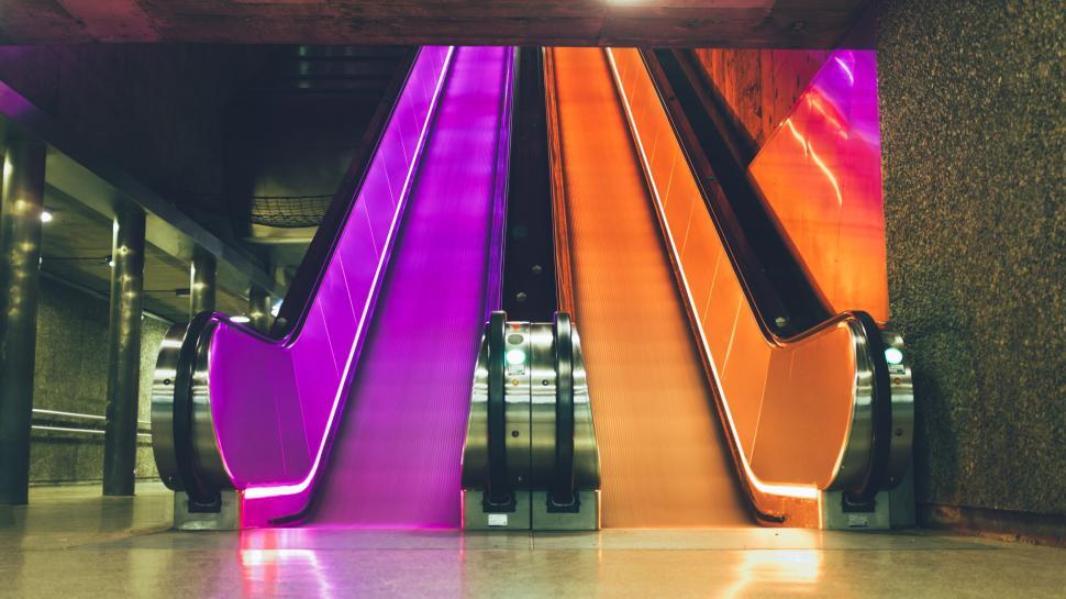 Free Image of Vibrant escalator in purple and orange hues 