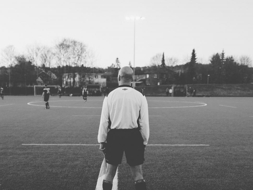 Free Image of Referee overseeing a soccer match at dusk 