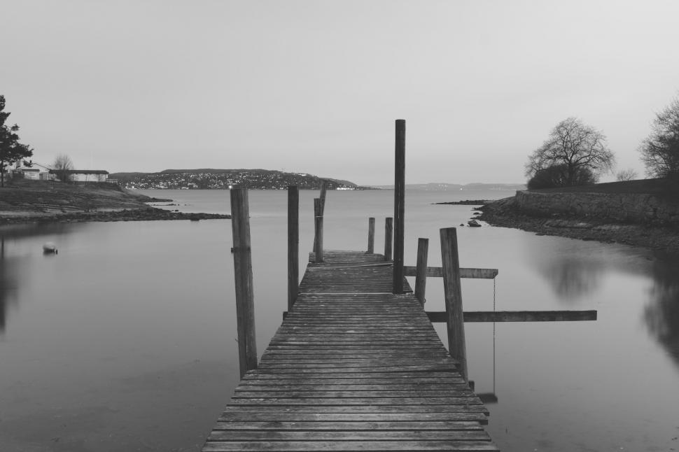 Free Image of Serene lakeside pier in grayscale tones 