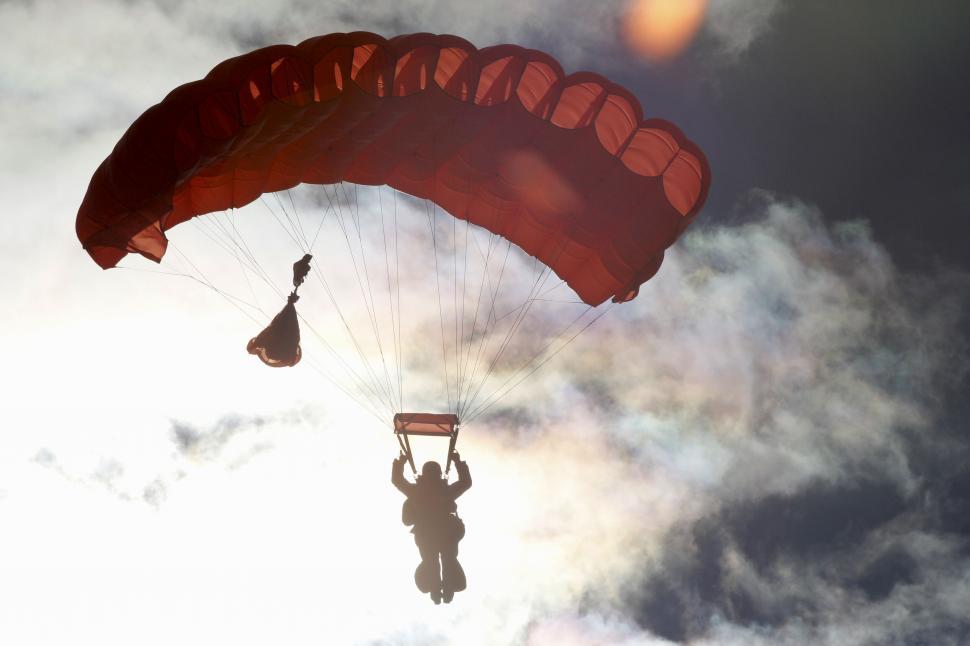 Free Image of Skydiver soaring amidst clouds at sunset 
