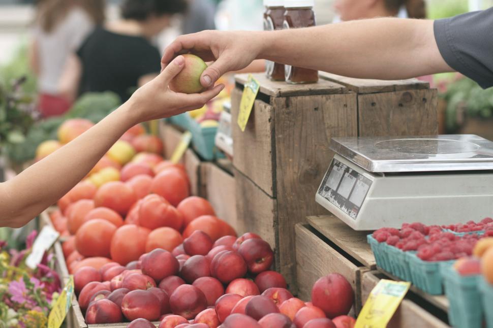 Free Image of Hand reaching for apple at a farmers market 