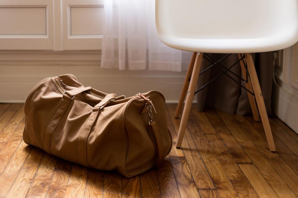 Free Image of Travel duffel bag on floor near modern chair 