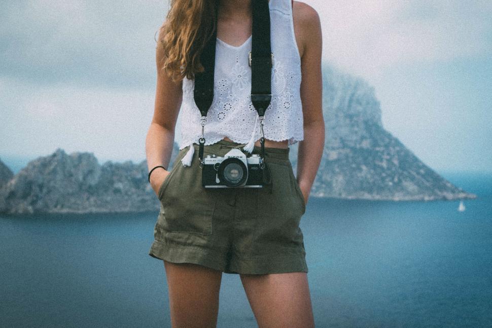 Free Image of Female traveler with camera overlooking the sea 